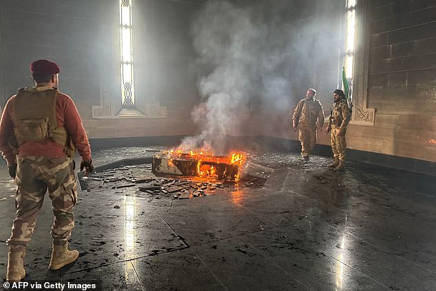 Rebel fighters set fire to the gravesite of Hafez al-Assad. Syrians for the first time in six decades look to a future without the Assad family