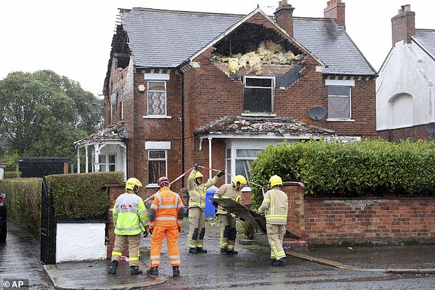 Firemen secure a house in Belfast that was damaged by the winds of Storm Eowyn on Friday