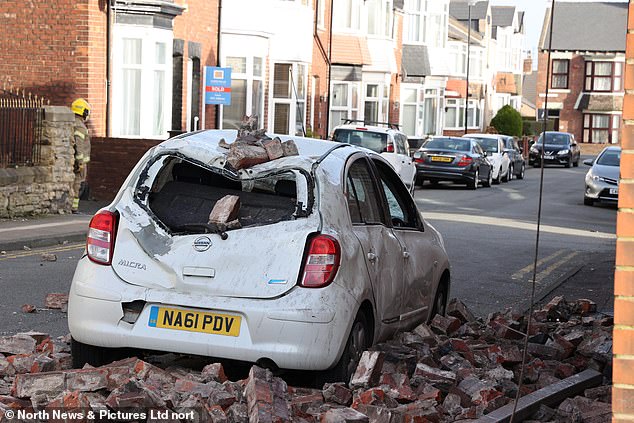 A Nissan Micra car is demolished under a pile of bricks on Newcastle Road in Sunderlandon Thursday