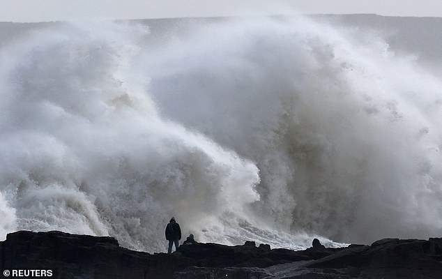 People view large waves as Storm Eowyn arrives at Porthcawl in Wales on Friday