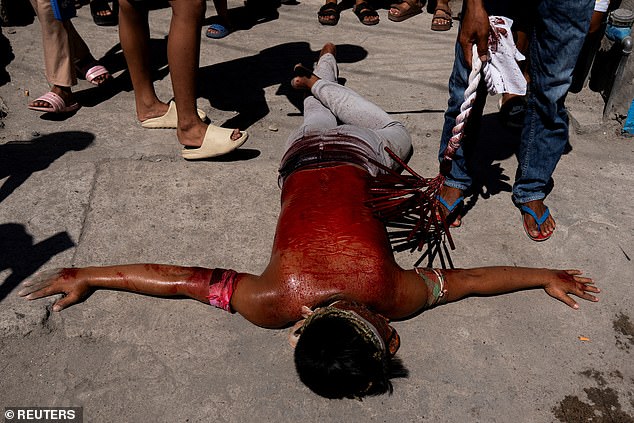 A Filipino penitent lies on the ground while being whipped as part of ritual self-flagellation, on Good Friday, in San Fernando, Pampanga, Philippines, April 18, 2025