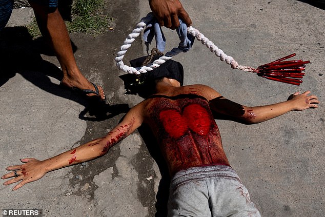 A Filipino penitent lies on the ground while being whipped as part of ritual self-flagellation, on Good Friday, in San Fernando, Pampanga, Philippines, April 18, 2025