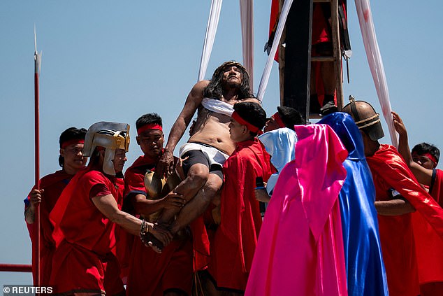 Filipino Catholic Ruben Enaje is carried after being nailed to the cross during his reenactment of the crucifixion of Jesus Christ on Good Friday, in San Fernando, Philippines, April 18, 2025