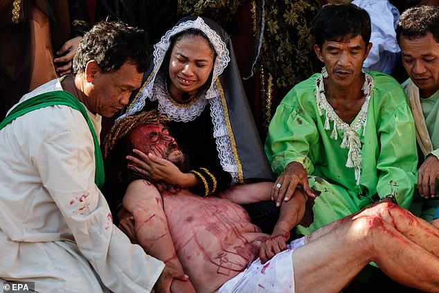 Catholic parishioners portray Jesus Christ (bottom C) and Mother Mary (2-L) in a scene of a 'Senakulo,' a depiction of events in the crucifixion and death of Jesus Christ to mark Maundy Thursday in the season of Lent in Paete town of Laguna province, Philippines 17 April 2025