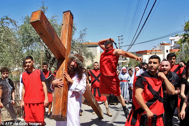 Lebanese men re-enact the crucifiction of Jesus Christ in the village of Qrayyeh, east of the coastal city of Sidon on April 18, 2025