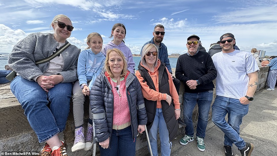 Viv Pyatt (on crutches), 61, from Probus, near Truro, Cornwall, and family wait to wave off her son Able Seaman Harry Pyatt, 24, who is serving on the Portsmouth-based supercarrier