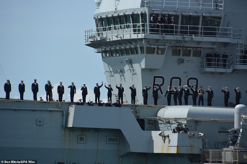 A total of 2,500 military personnel - about 2,100 British, 400 from Norway, Canada and Spain - will initially deploy as part of the CSG. Pictured are members of HMS Prince of Wales' ship's company on the aircraft carrier's deck