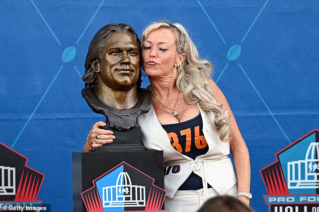 McMichael's wife, Misty, poses with his bust during the 2024 enshrinement ceremony