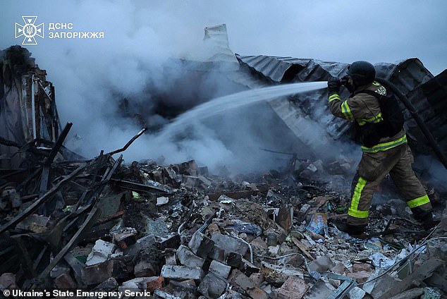 A firefighter mans a hose as they work to extinguish a fire following an aerial guided bomb in Zaporizhzhia region, Ukraine on Monday, March 31, 2025