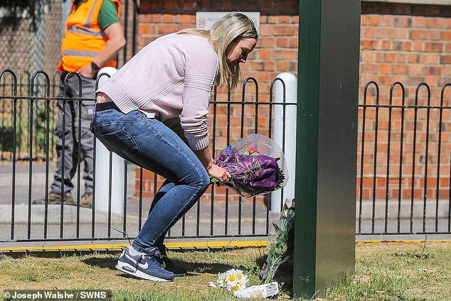 A member of the public leaves flowers at the scene of the Bicester Motion buildings in Bicester, Oxfordshire on May 16, 2025