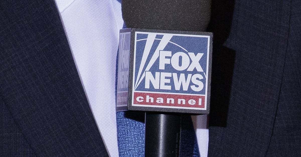 A Fox News correspondent holds a Fox News microphone.