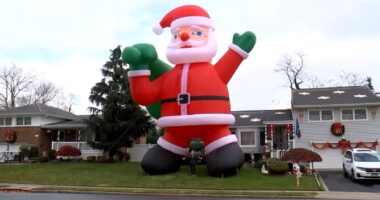 Homeowner's enormous inflatable Santa Claus balloon brings extra holiday spirit to Farmingdale, New York residents on Long Island