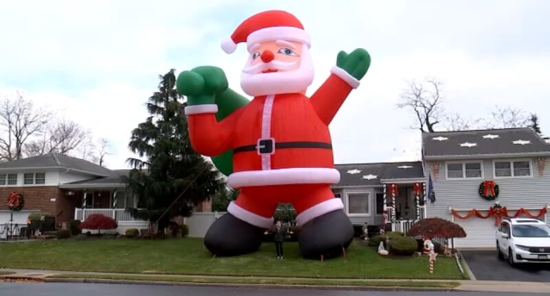 Homeowner's enormous inflatable Santa Claus balloon brings extra holiday spirit to Farmingdale, New York residents on Long Island