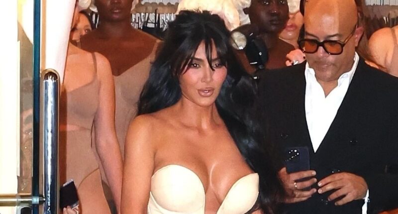 Busty Kim Kardashian wheels herself into SKIMS store with broken foot driving fans wild: 'Still put a heel on it!'