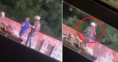 Shocking moment police officer throws delivery worker off BRIDGE in Brazil during traffic stop