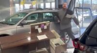 Watch moment raging driver smashes brand new car through dealership window while furiously demanding a refund