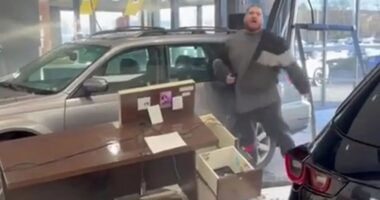 Watch moment raging driver smashes brand new car through dealership window while furiously demanding a refund