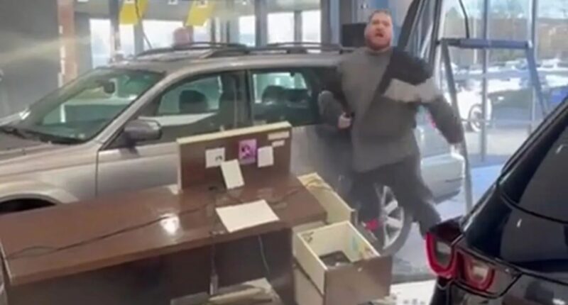 Watch moment raging driver smashes brand new car through dealership window while furiously demanding a refund