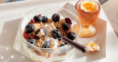 bowl of yogurt with berries and granola with an egg