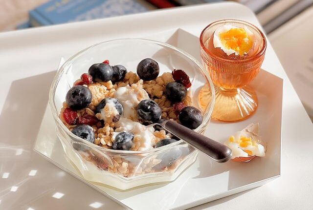 bowl of yogurt with berries and granola with an egg