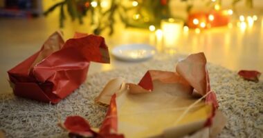 Empty gift wrapping under the tree on Christmas morning. A plate of cookie crumbs and an empty milk glass after a night visit from Santa Claus. Santa delivered gifts under the Christmas tree.