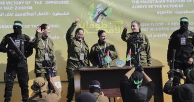 Israeli female soldier hostages wave at a Palestinian crowd