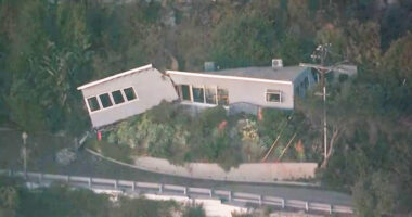 Home that survived LA blaze is split in HALF by mudslide triggered by firefight as water and debris barrel down hill