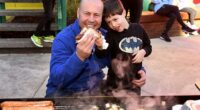 Treasurer Josh Frydenberg enjoys a sausage with son Blake after voting on Saturday