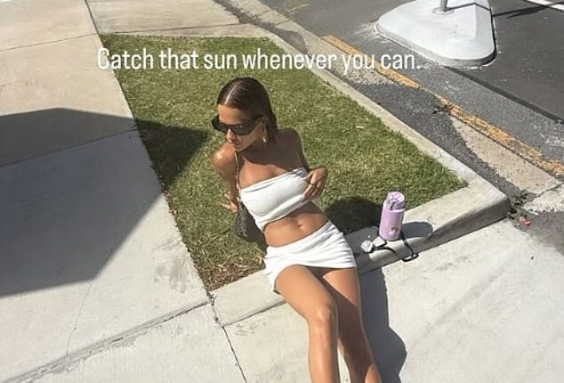 Rita Ora wowed in a white two-piece as she sunbathed on the pavement during her New Zealand holiday in an Instagram post on Tuesday