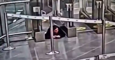 Watch moment woman crawls under airport security barrier before sneaking onto PLANE completely unnoticed