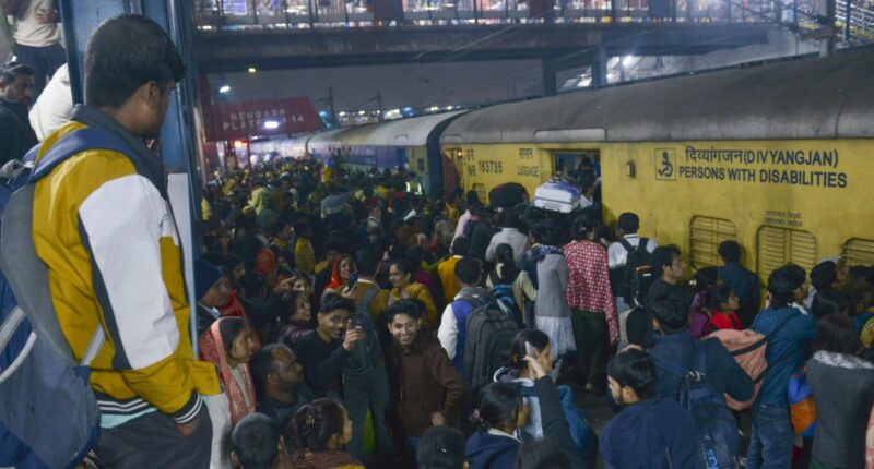 At least 18 people killed in stampede at station as thousands push to board train on way to Indian religious festival