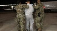 Dramatic moment chained migrants are marched into terror hellhole Guantanamo Bay after Trump’s crackdown