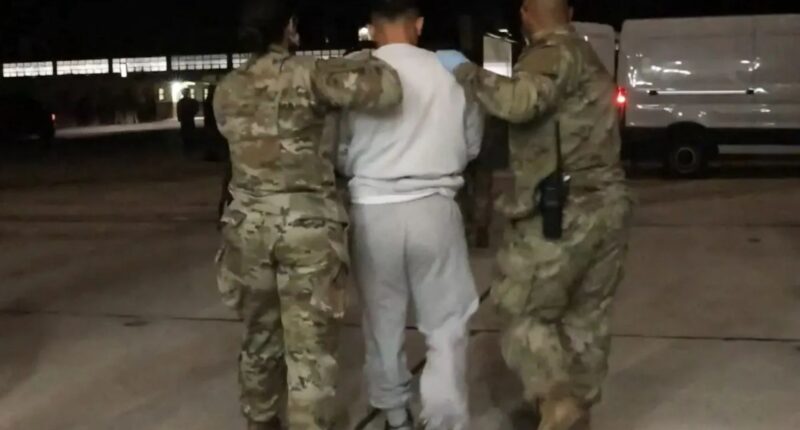 Dramatic moment chained migrants are marched into terror hellhole Guantanamo Bay after Trump’s crackdown