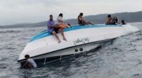 Passengers sit on a boat carrying tourists including a number of Australians that capsized in the waters off Nusa Penida Island, in Bali.