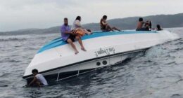 Passengers sit on a boat carrying tourists including a number of Australians that capsized in the waters off Nusa Penida Island, in Bali.