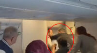 Horror moment crazed passenger tries to OPEN plane door during packed flight at 35,000ft as others rush to tackle him