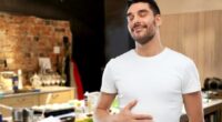 happy full man touching his tummy over kitchen background