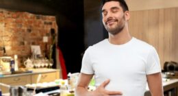 happy full man touching his tummy over kitchen background