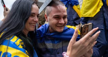 Homecoming Ukrainian soldiers are embraced by families after latest prisoner exchange with Russia - hours after Putin's army launched huge drone attack