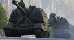 Putin and President Xi watch Russia's Victory Day Parade in Moscow as Ukraine says it 'cannot guarantee the safety' of those attending - and experts warn of WW3 'in one year'