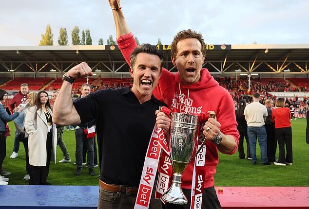 Wrexham co-owners Rob McElhenney and Ryan Reynolds celebrate with the League One trophy