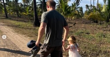 'Daddy's little girl': Meghan Markle shares more unseen snaps of Lilibet on her fourth birthday showing Prince Harry cradling her in his arms and walking together hand-in-hand