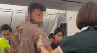 Dramatic moment boozed up passenger is hauled off busy plane after VOMITING on another flier