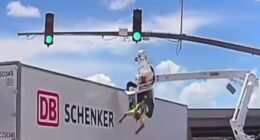 Horror moment worker is smashed into by huge 18-wheeler leaving him dangling from basket upside down above busy road