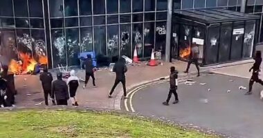 Leisure Centre 'being used as emergency accommodation for immigrants' goes up in flames after being set on fire by masked yobs: Riot cops swarm streets as Northern Ireland enters its third night of unrest 