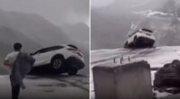 Terrifying moment car dangles precariously over sheer cliff drop sparking frantic mission to save occupants inside