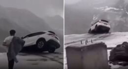 Terrifying moment car dangles precariously over sheer cliff drop sparking frantic mission to save occupants inside