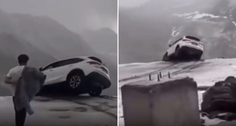 Terrifying moment car dangles precariously over sheer cliff drop sparking frantic mission to save occupants inside